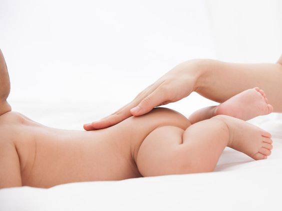 Maman qui masse doucement son b&eacute;b&eacute;